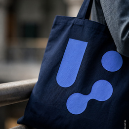Shopper in cotone blu navy, il logo grande stampato sul fronte — foto ambientata